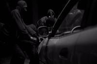 a group of men standing next to a car