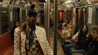 a man standing on a subway train next to a group of people