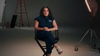 a woman sitting in a chair in front of a camera