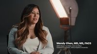 a woman is standing in front of a light