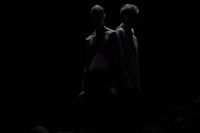 a couple of men standing next to each other in the dark