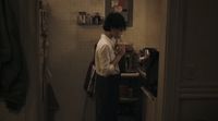 a woman standing in a kitchen preparing food