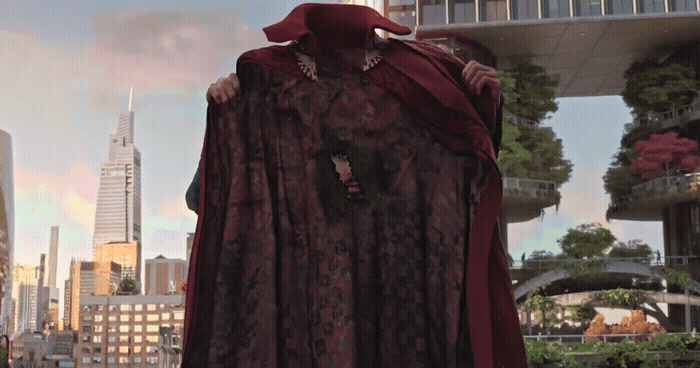 a statue of a woman wearing a red cape in front of a cityscape