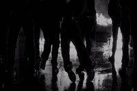 a group of people walking down a street at night