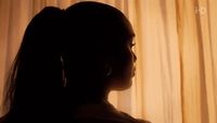 a silhouette of a woman in front of a curtain