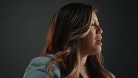 a woman with long hair and a blue jacket