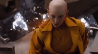 a bald man in a yellow trench coat