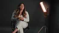 a woman sitting in a chair in front of a light