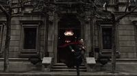 a man in a red cape is standing in front of a building