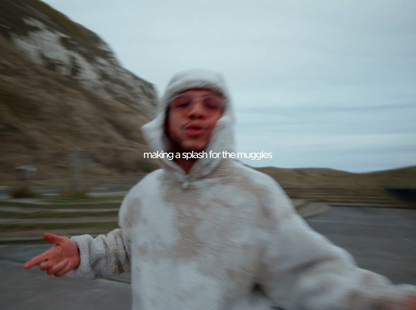 a man in a white hoodie holding his hands out