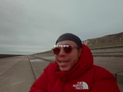 a man wearing a red jacket and sunglasses