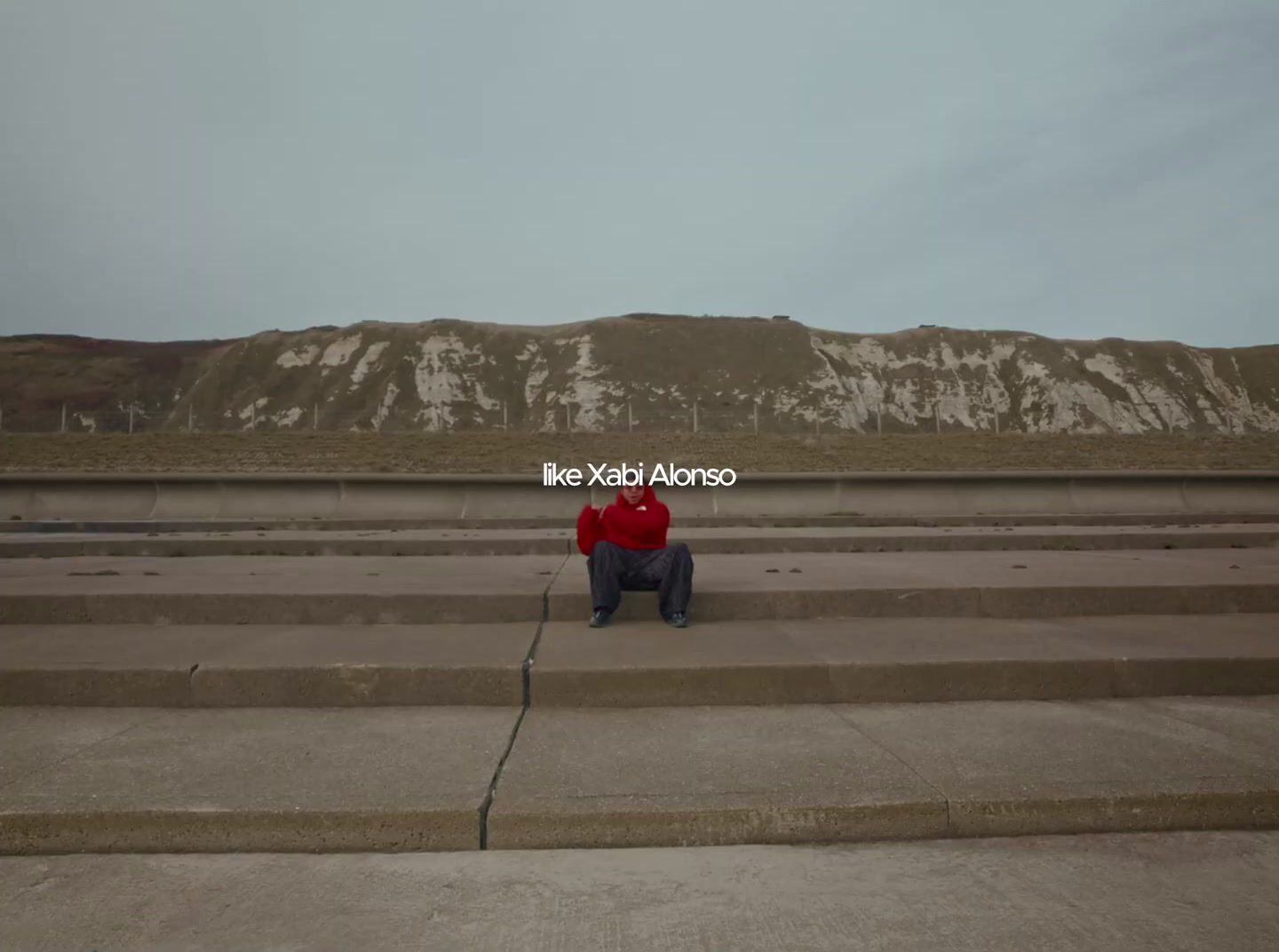 a person in a red jacket sitting on some steps