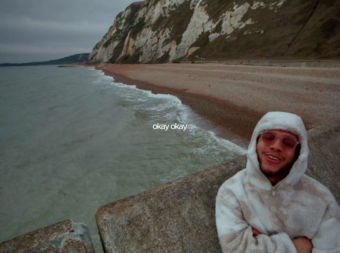 a man in a white robe standing next to a body of water