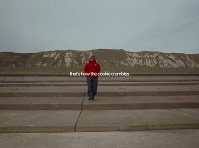 a man in a red jacket is standing on some steps