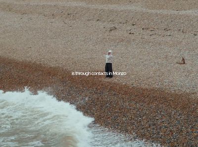 a man standing on top of a beach next to the ocean