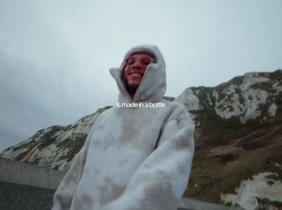 a man in a cow print hoodie standing in front of a mountain