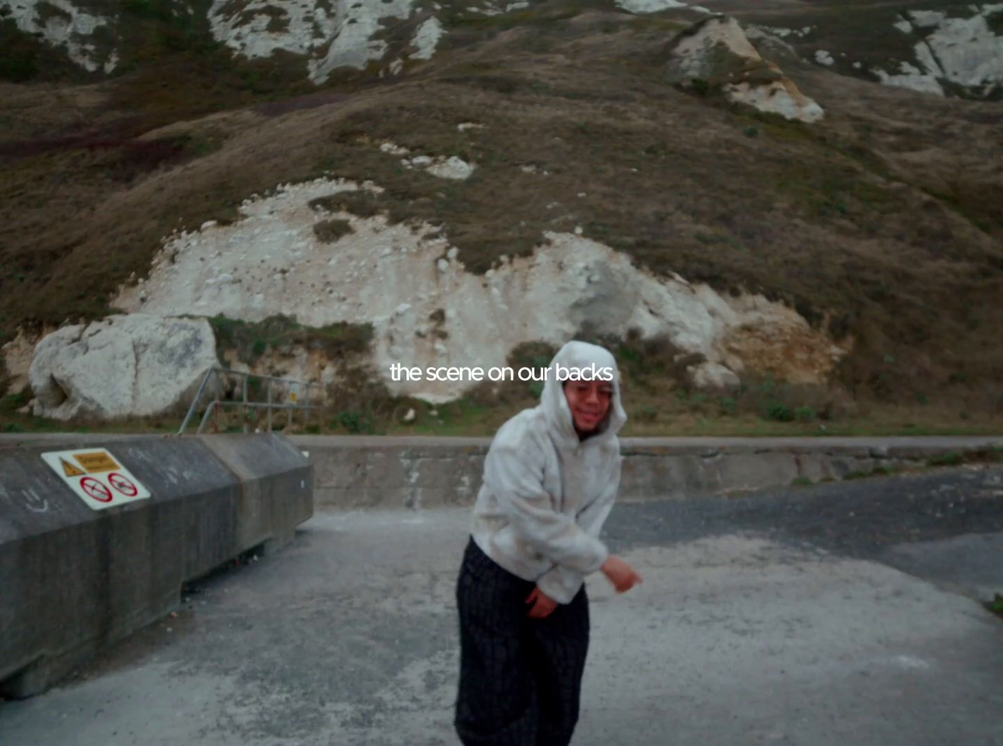 a man in a white hoodie is skateboarding