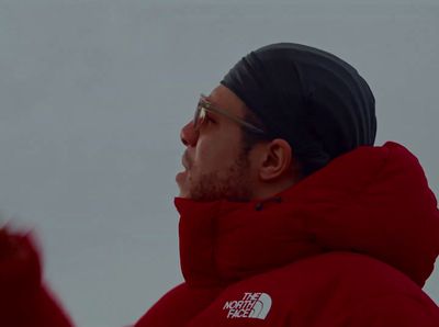 a man wearing a red jacket and a black hat