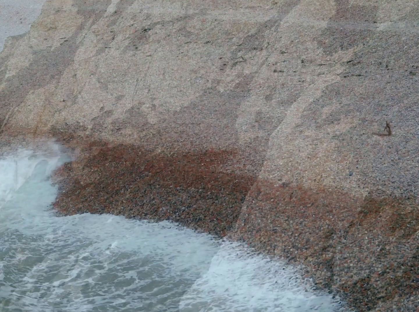 a man standing on a cliff next to a body of water