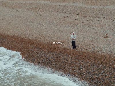 a man standing on a beach next to the ocean