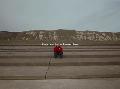 a person sitting on a concrete step in front of a mountain