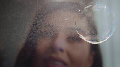 a close up of a person's face with a bubble in front of them