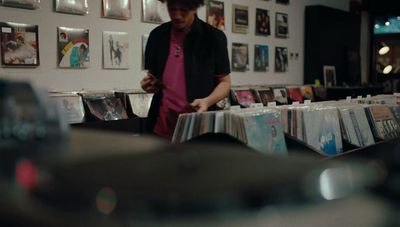 a man standing in front of a table filled with cds