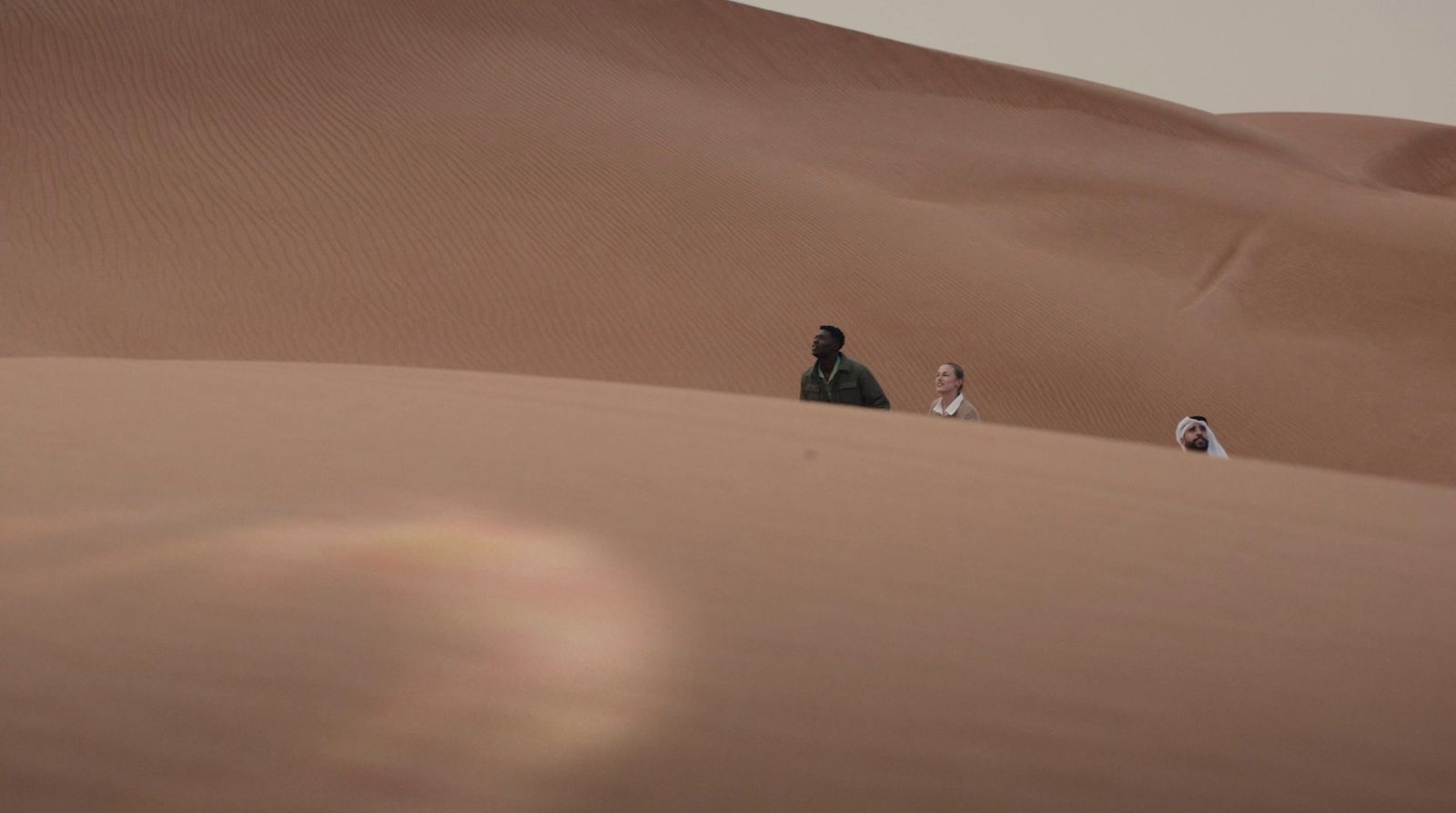 a group of people standing in the middle of a desert