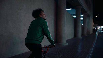 a man riding a bike down a street at night