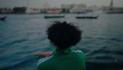 a woman pointing at boats in the water