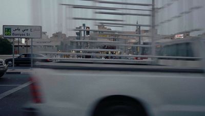 a white truck driving down a street next to tall buildings