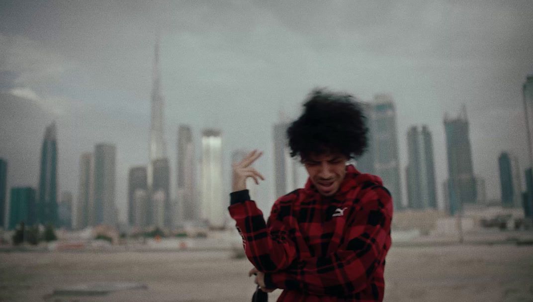 a man in a red and black checkered shirt holding a cell phone