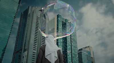 a person standing in front of tall buildings with a bubble in their mouth