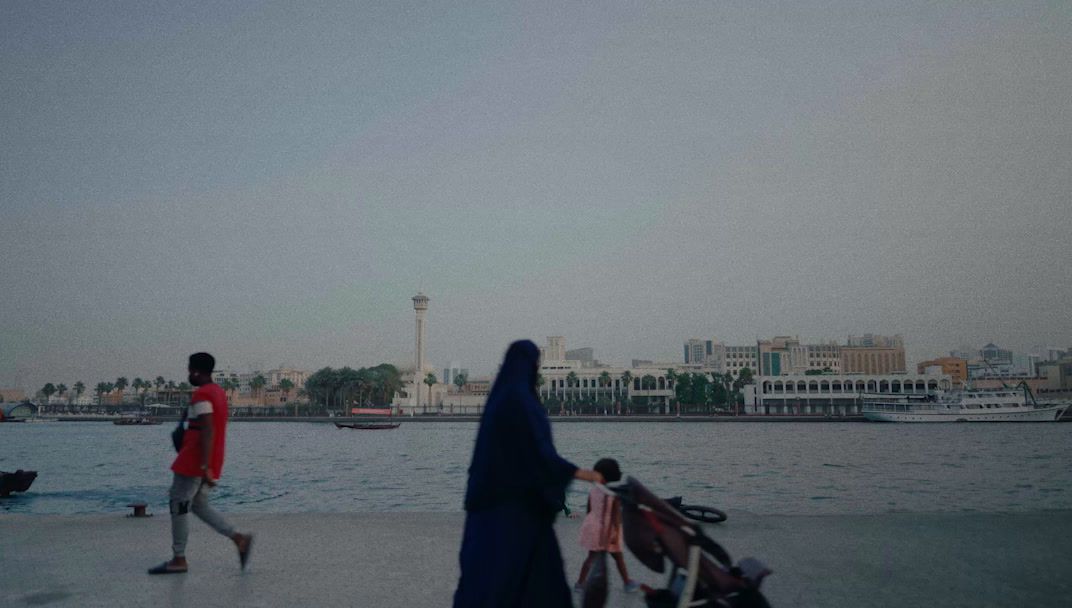 a man and a woman walking by a body of water