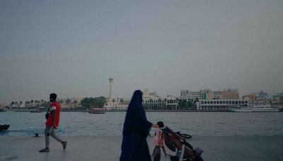 a man and a woman walking by a body of water