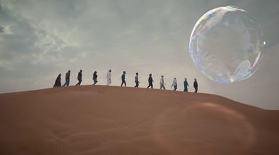 a group of people standing on top of a sand dune