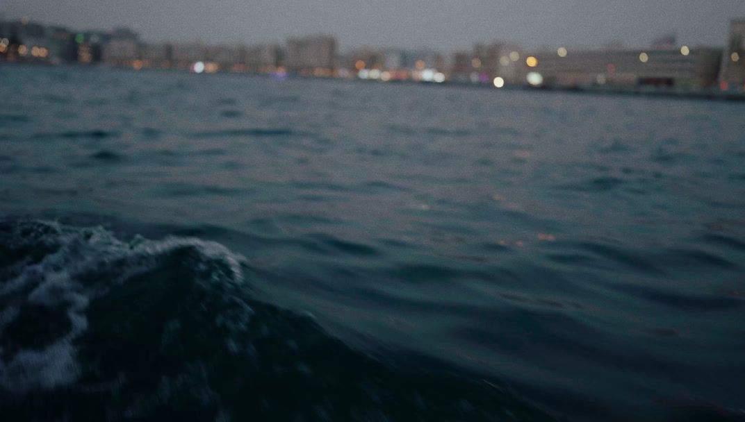 a body of water with a city in the background