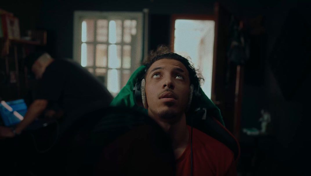 a man with headphones looking up in a dark room