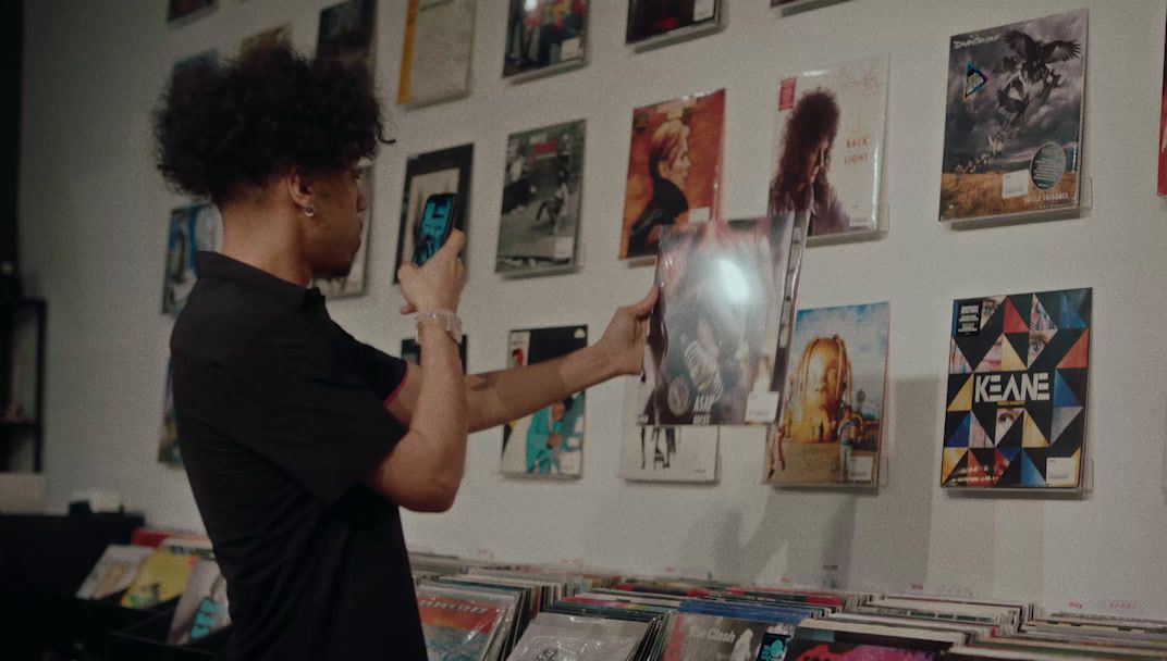 a woman standing in front of a wall covered in posters