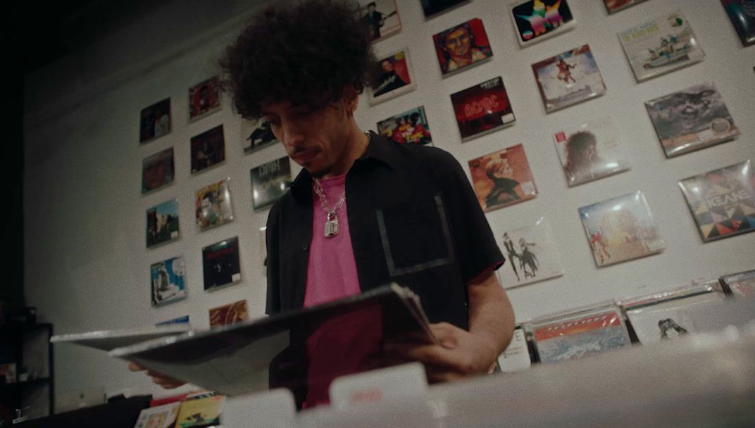 a man standing in front of a wall covered in pictures