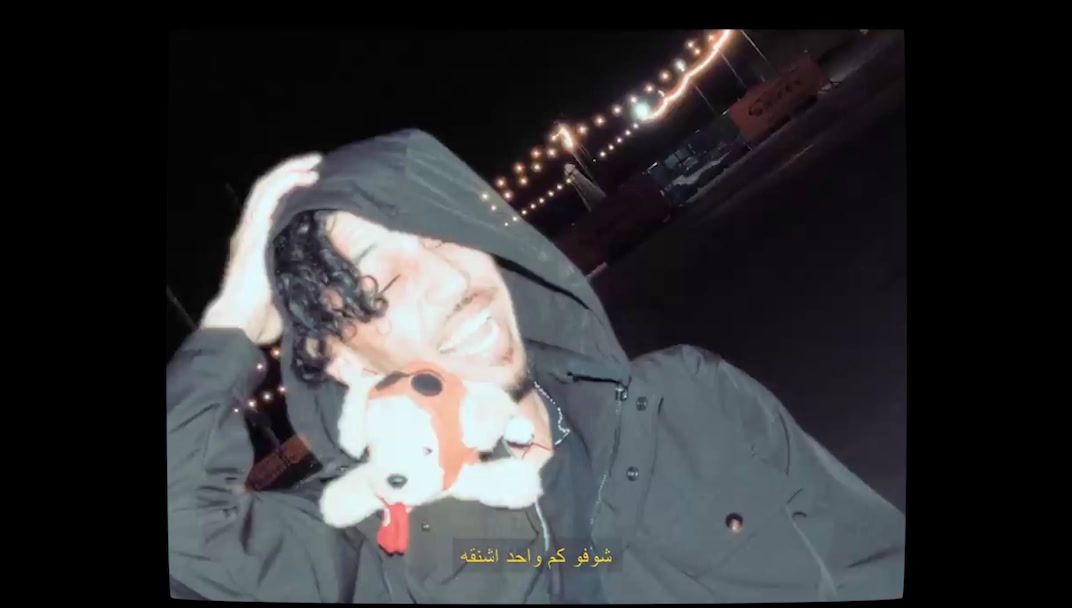 a man in a hooded jacket holding a stuffed animal