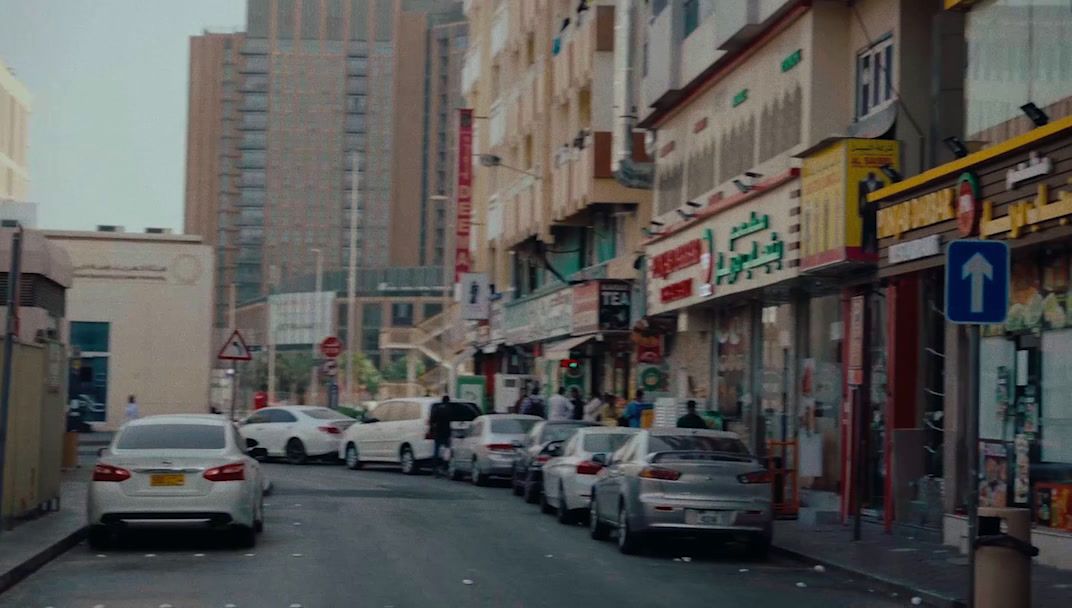 a city street filled with lots of traffic next to tall buildings