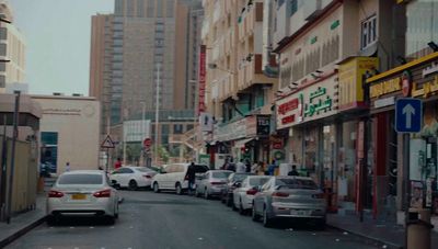 a city street filled with lots of traffic next to tall buildings