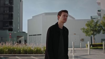 a man standing in a parking lot next to a building