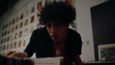 a man with curly hair sitting at a desk