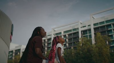 a man and a woman standing in front of a building