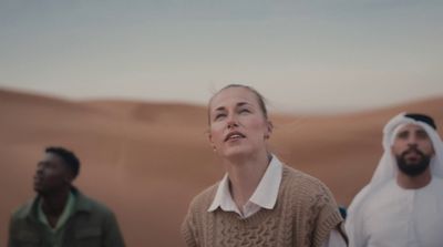 two men and a woman standing in the desert