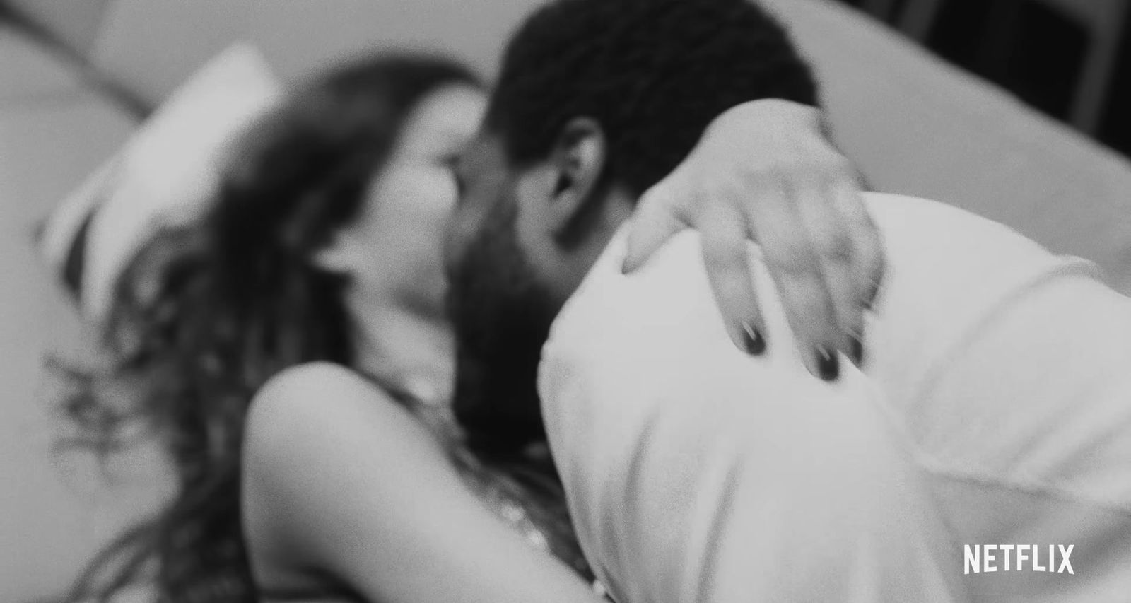 a black and white photo of a man kissing a woman