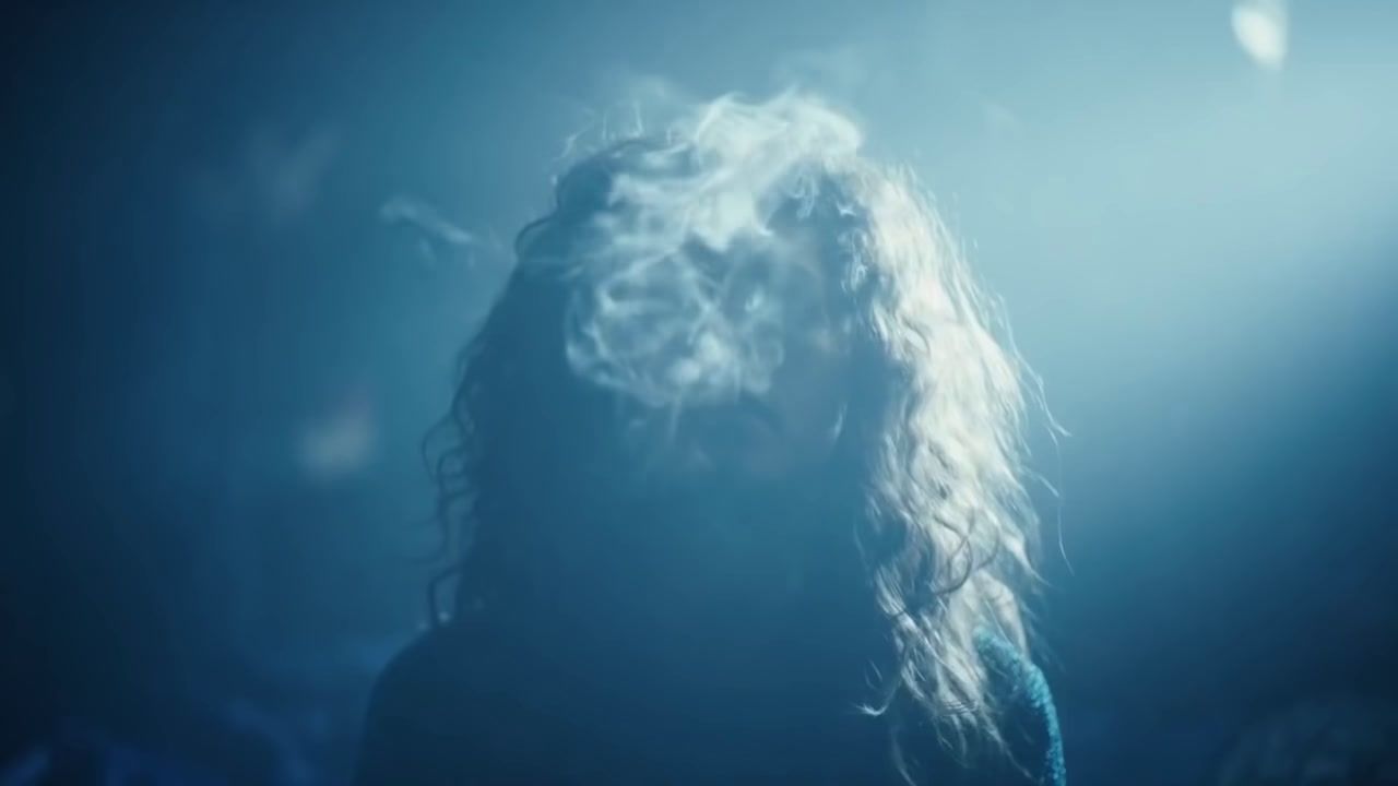 a woman with long hair standing in a dark room