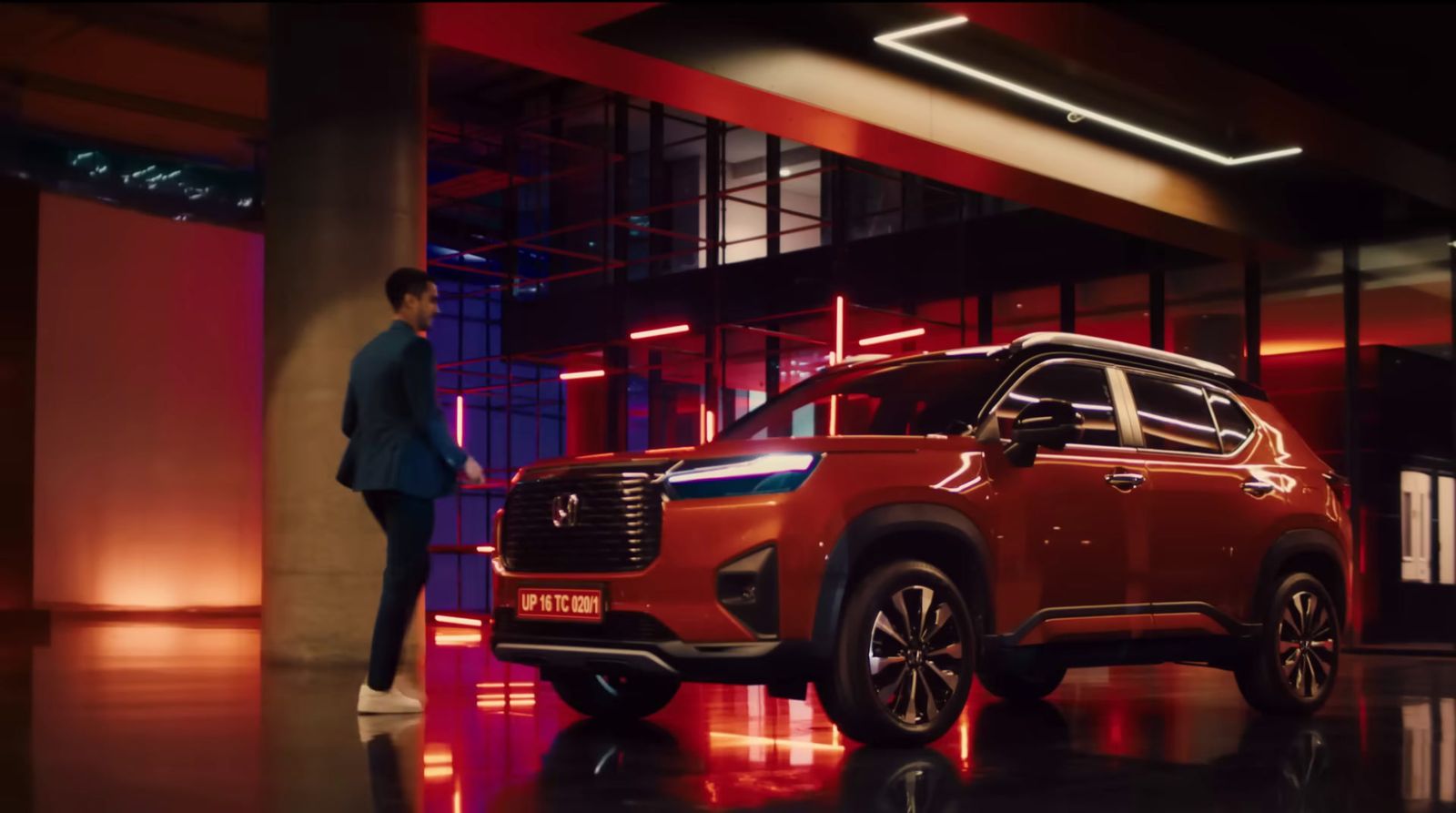 a man standing next to a red suv